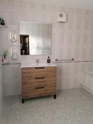 a bathroom with a sink and a mirror at Casa López in San Mamede de Carnota