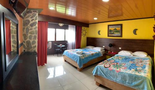 a hotel room with two beds and a table at Cabinas Vista Al Golfo in Monteverde Costa Rica