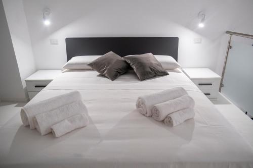 een wit bed met handdoeken erop bij Dadà Loft in Cefalù