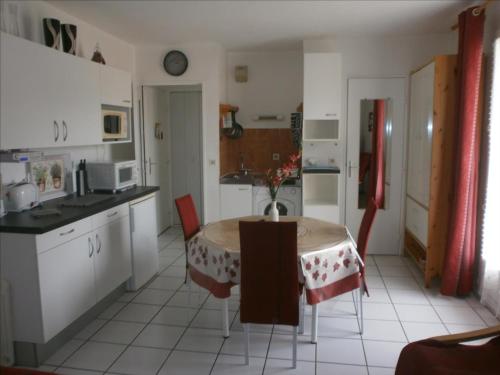une cuisine avec une table avec un vase dessus dans l'établissement Superbe studio résidence le Galion 81, à Digne-Les-Bains