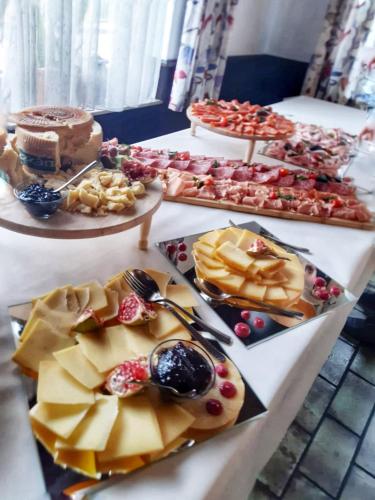 uma mesa cheia de diferentes tipos de alimentos em pratos em Hotel Grüner Baum - Hotel im Murgtal, Schwarzwald em Weisenbach