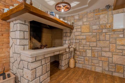 a stone fireplace in a kitchen with a stone wall at Apartment Jurasić in Orlec