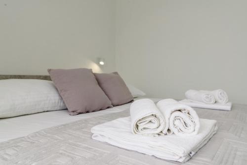 a bed with towels and pillows on it at Apartments Pelja in Trogir