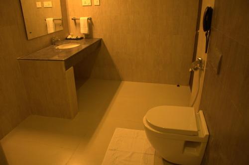 a small bathroom with a toilet and a sink at Renest Tirupati in Tirupati