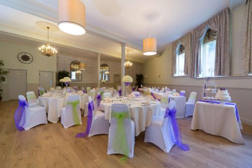 a room with white tables and chairs with purple bows at Best Western Limpley Stoke Hotel in Bath