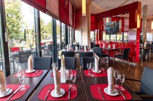 un comedor con servilletas rojas y copas de vino en Best Western Plus Konrad Zuse Hotel, en Hünfeld