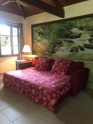 um quarto com uma cama roxa com um quadro na parede em Presbytère de cassagnes em Cassagnes