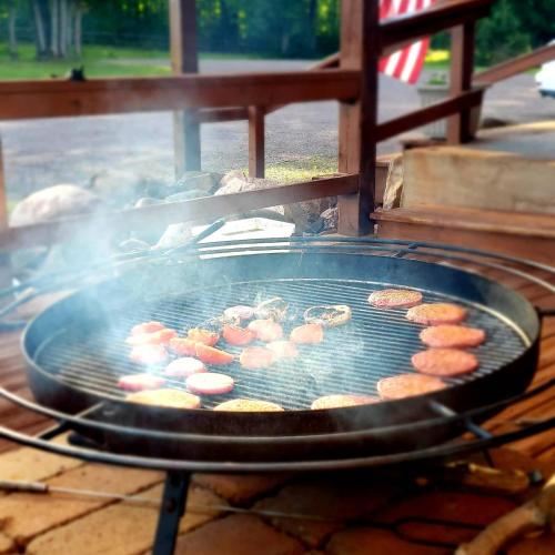 a grill with a bunch of food cooking on it at North Ironwood Acres - Black River Lodge in Ironwood