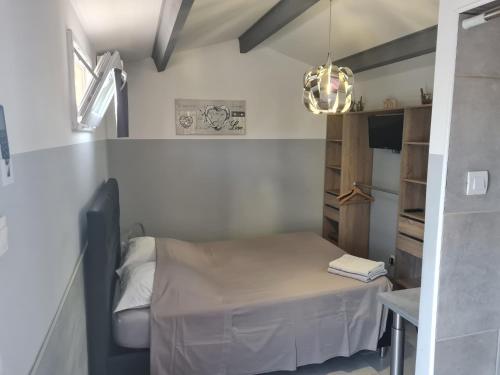 um pequeno quarto com uma cama num quarto em Chambre cosy avec terrasse em Arles