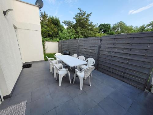 a patio with a table and chairs and a fence at 100m2 2 chambres 8 personnes - Grand parking et terrasse privée - Proche CDG-Parc expositions-Paris-Astérix-Disney in Villepinte