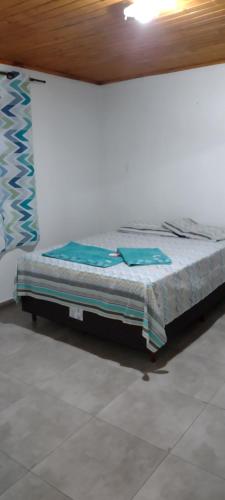 una cama sentada en una habitación junto a una pared en POUSADA IDEAL, en Uruguaiana