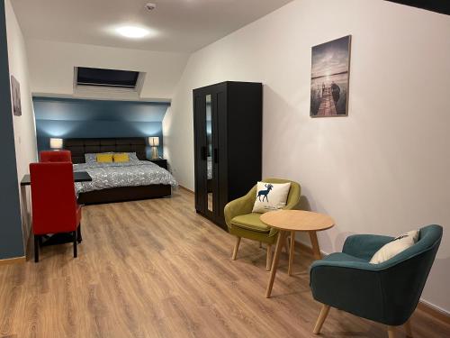 a room with a bed and two chairs and a table at Gîtes de la Croisette 3 in Dinant