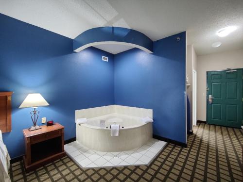 bañera en una habitación con pared azul en Baymont by Wyndham Albany, en Albany