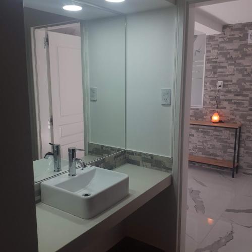a bathroom with a sink and a mirror at Cabañas Tunita´s in Coronel Suárez