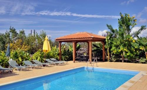 a swimming pool with chairs and a gazebo at Peyia Villas Cyprus in Peyia