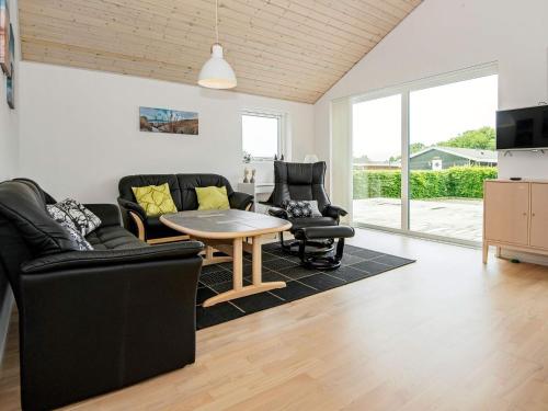 ein Wohnzimmer mit 2 Stühlen und einem Tisch in der Unterkunft 6 person holiday home in Bjert in Binderup Strand