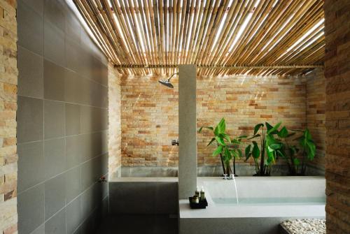 a bathroom with a shower and a bath tub at Sarikantang Resort & Spa, Koh Phangan in Haad Rin