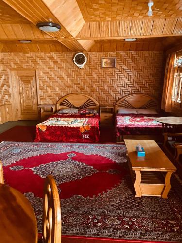 a room with two beds and a table at Riverside Hotel Kalam in Kārandūkai