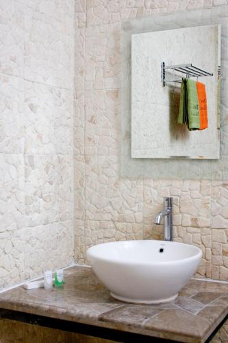 a bathroom with a white sink and a mirror at Osmond Villa Resort in Lembang
