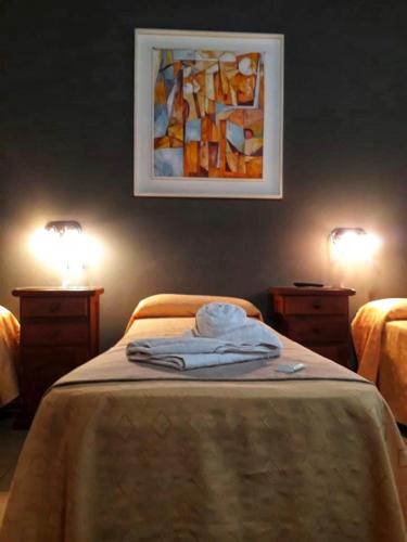 a bed with two night stands and a painting on the wall at Lion D`Or in Villa Carlos Paz