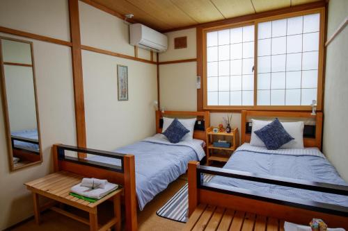 A bed or beds in a room at Myoko Mountain Lodge