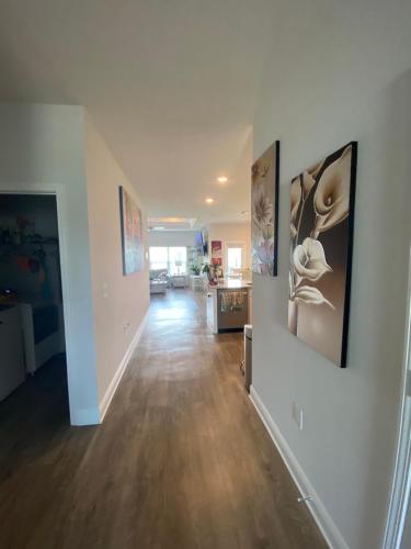 a hallway of a home with paintings on the walls at Beach Room, for wonderful Vacation in Panama City Beach