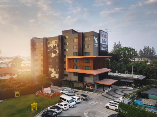 a building with cars parked in a parking lot at Moose Hotel Chiangmai in Chiang Mai