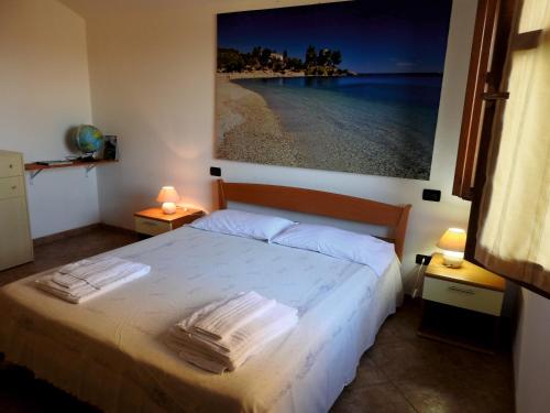a bedroom with a bed and a painting on the wall at Casa Cala Luna in Santa Maria Navarrese
