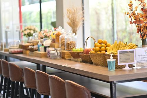a long table with baskets of fruit on it at Moose Hotel Chiangmai in Chiang Mai
