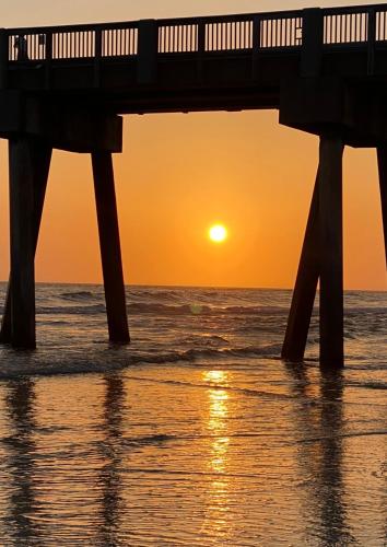 a pier over the ocean at sunset at Beach Room, for wonderful Vacation in Panama City Beach