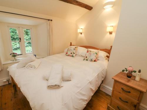 A bed or beds in a room at 2 Storrs Cottages