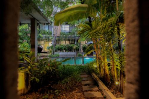 a swimming pool in a garden with plants at Larimar Hotel & Resort in Phnom Penh