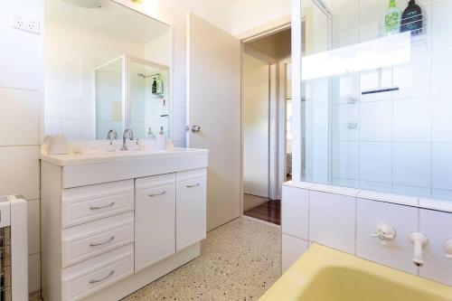a white bathroom with a sink and a shower at Riverview Cottage in Ipswich