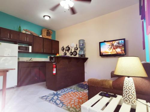 a kitchen with a couch and a tv on the wall at BELIZE TROPICAL DREAM VILLAS in San Pedro