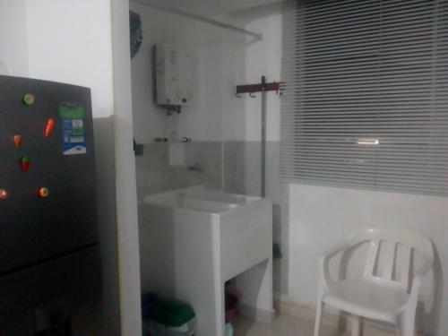 een badkamer met een witte wastafel en een witte stoel bij BRISAS DEL QUINDIo 2 apto 203 A in Montenegro