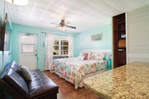 um quarto com uma cama e um sofá num quarto em Tropic Terrace #23 - Beachfront Rental condo em St. Pete Beach