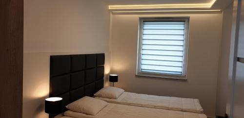 Ένα ή περισσότερα κρεβάτια σε δωμάτιο στο Porta Mare Apartamenty Słoneczne Tarasy