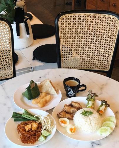a table with three plates of food on it at Blu Monkey Hub & Hotel Surat Thani in Surat Thani