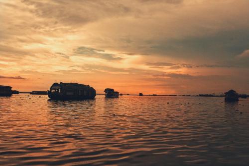 a boat sitting in the water at sunset at Oceana Hills Residency in Alleppey