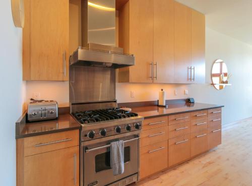 a kitchen with a stainless steel stove and wooden cabinets at Columbia River Gorge View FOUR Condo in Hood River