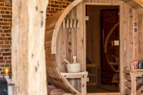 a wooden room with a wooden door and a barrel at De Hoeveschuur in Riemst