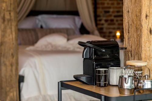 a coffee maker on a table next to a bed at De Hoeveschuur in Riemst