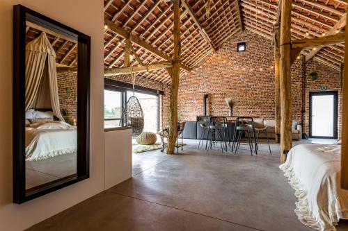 a barn conversion with a bedroom and a dining room at De Hoeveschuur in Riemst