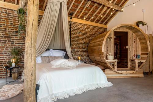 a bedroom with a bed and a brick wall at De Hoeveschuur in Riemst