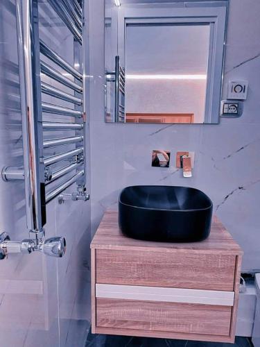 a bathroom with a black sink on a wooden counter at KEFA SUITE in Cefalù