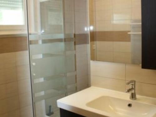 uma casa de banho com um lavatório e uma cabina de duche em vidro. em Gîte Xonrupt-Longemer, 3 pièces, 4 personnes - FR-1-589-218 em Xonrupt-Longemer