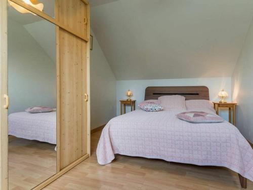 um quarto com 2 camas e um espelho grande em Gîte Mesquer, 4 pièces, 5 personnes - FR-1-306-1068 em Mesquer