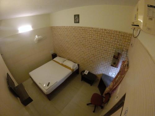 a small room with a bed and a staircase at Just Guest House, Chennai Airport in Chennai