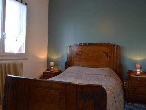 een slaapkamer met een houten bed en 2 nachtkastjes met lampen bij Gîte Montipouret, 3 pièces, 4 personnes - FR-1-591-190 in Montipouret