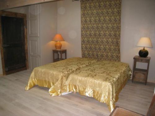 ein Schlafzimmer mit einem Bett mit einer goldenen Tagesdecke in der Unterkunft Gîte Tonnoy, 3 pièces, 4 personnes - FR-1-584-35 in Tonnoy